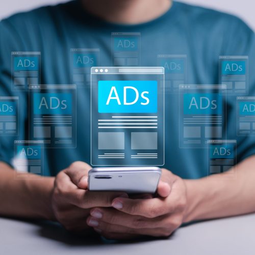 digital marketing and online advertising to targeted customers shooting ads on cross feeds to optimize customer engagement person using mobile smartphone with virtual screen of ads on website